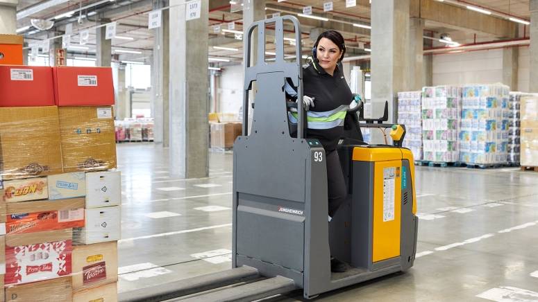 Pracownik magazynu przewozi towar na wózku widłowym
