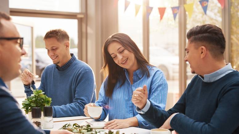 Pracownicy biura piją kawę w kantynie.